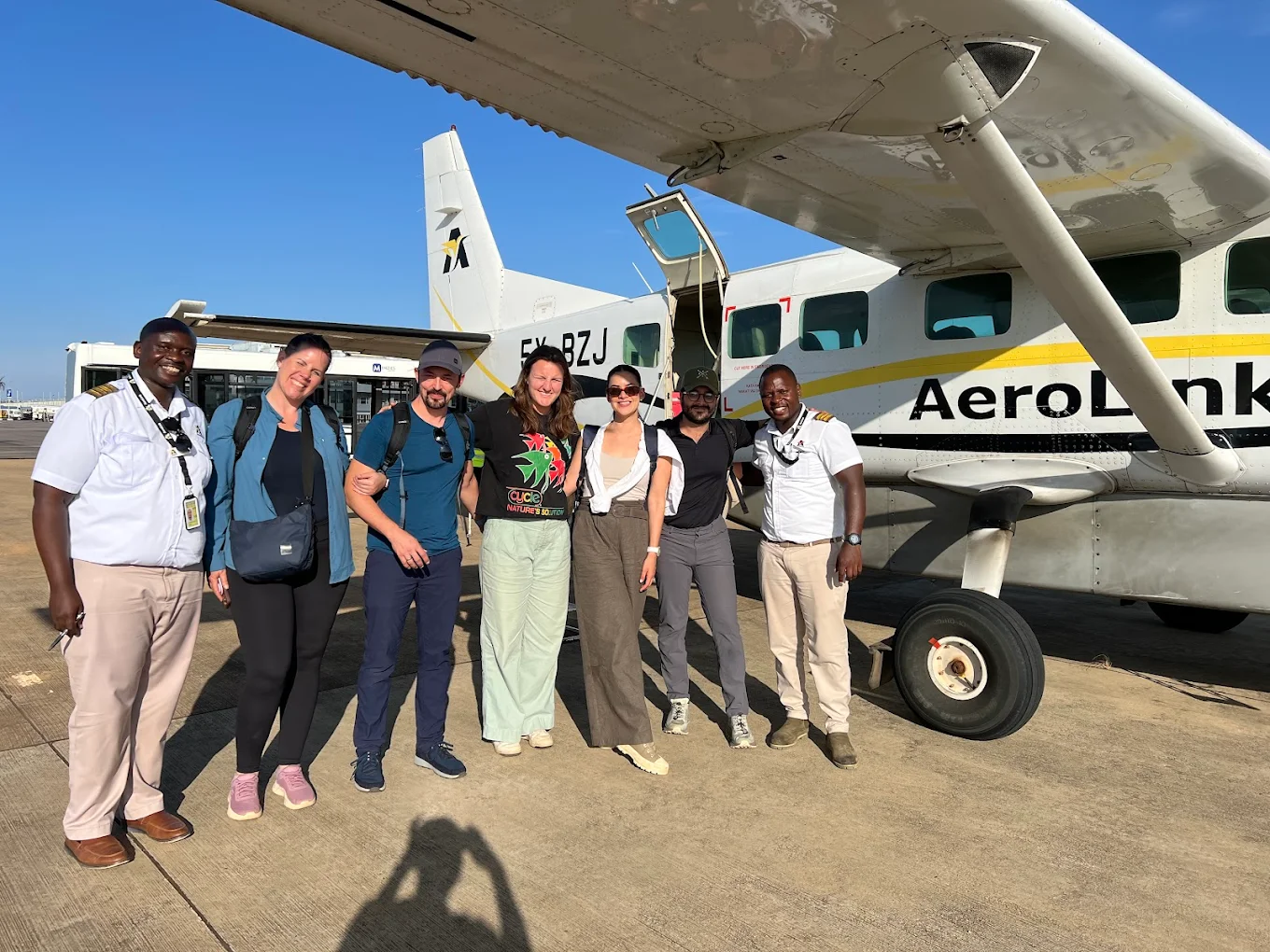 Ultimate Gorilla Trekking in Uganda Guide 9 Travelers preparing for a fly-in gorilla trekking safari in Uganda beside a domestic safari aircraft
