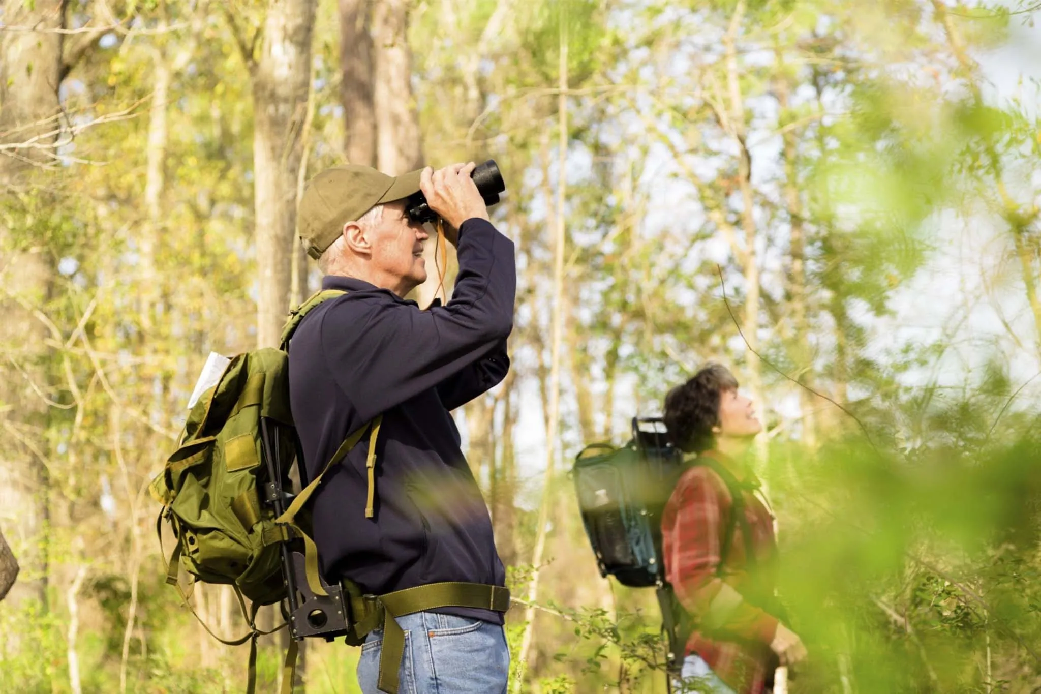Best Uganda Luxury Holidays 2026/2027: Ultimate Safari Guide 41 Travelers using binoculars while birdwatching in a forest during a luxury birding experience in Uganda