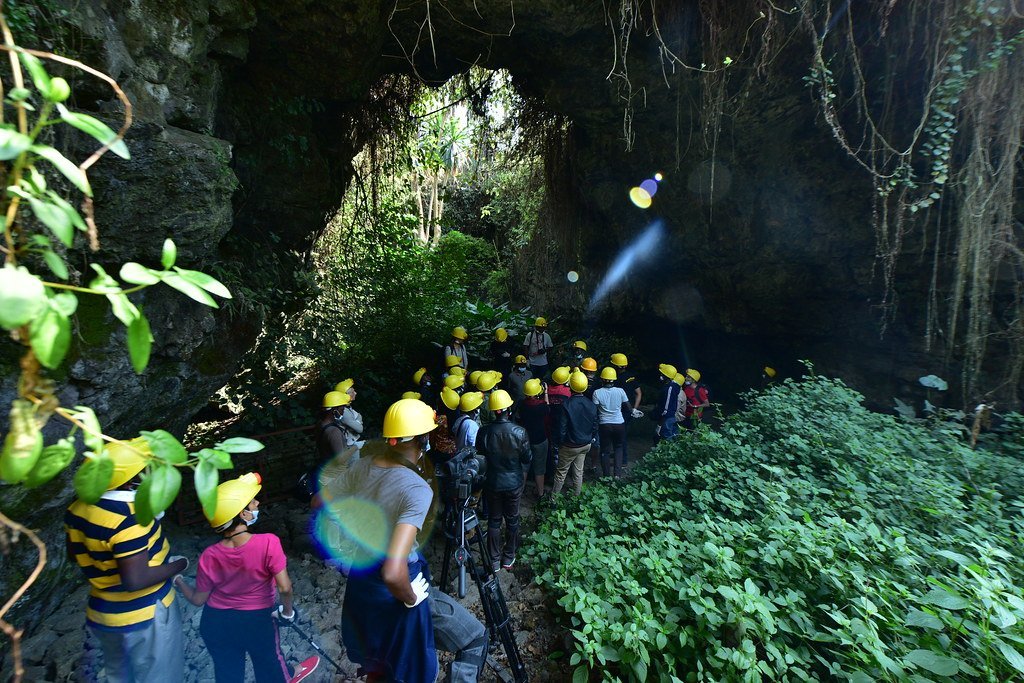 Volcanoes National Park Guide: Best Safari Tips in 2026/2027 17 Visitors wearing safety helmets exploring the volcanic Musanze Caves near Volcanoes National Park in Rwanda
