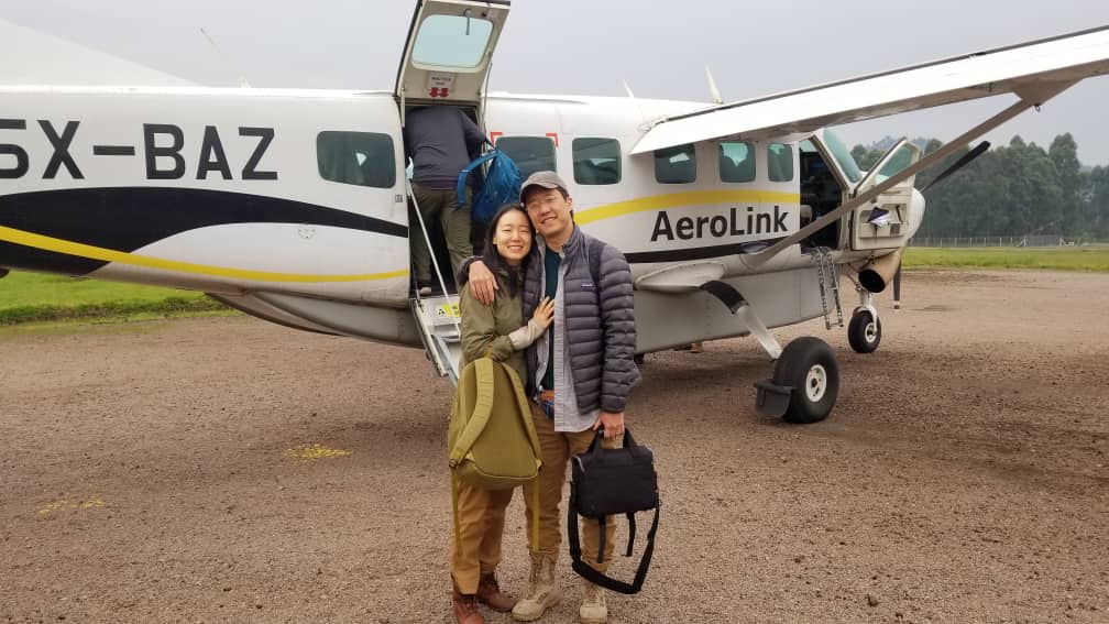 Ultimate Uganda Airport Guide: Best Travel Tips (2026/2027) 21 Travelers beside an Aerolink safari aircraft at Kasese Airfield, a convenient gateway to Queen Elizabeth National Park and western Uganda