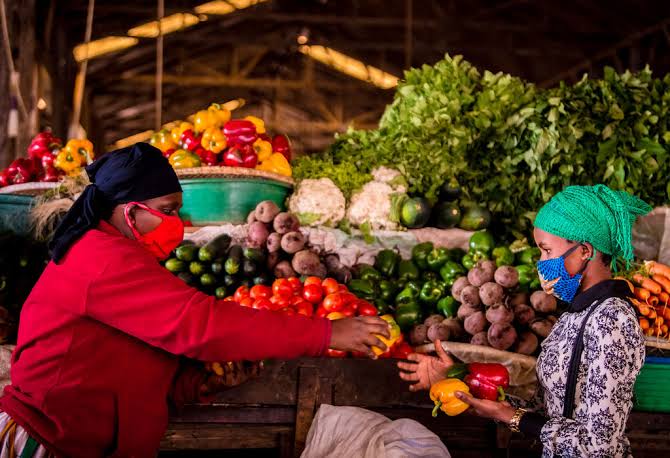 kigali city tour 19 Shoppers buying fresh fruits and vegetables at Kimironko Market in Kigali, Rwanda.
