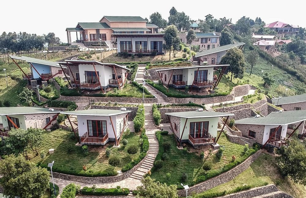 Best Uganda Luxury Holidays 2026/2027: Ultimate Safari Guide 23 Luxury safari lodge cottages built on green hills near Bwindi Impenetrable National Park in Uganda
