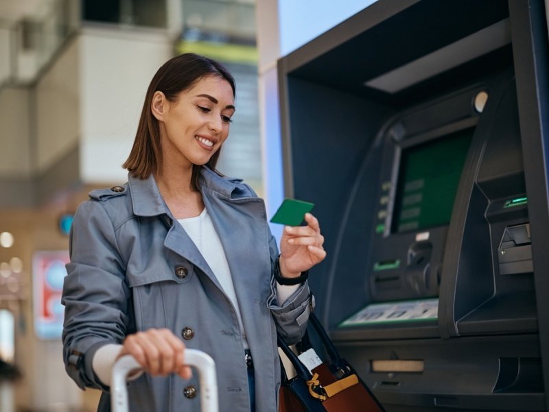 Ultimate Uganda Airport Guide: Best Travel Tips (2026/2027) 7 International traveler using an ATM, representing banking, cash withdrawal and foreign exchange services at Entebbe International Airport in Uganda