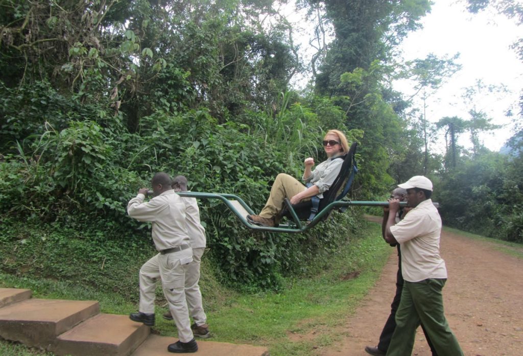 7 Day Uganda Safari: Best Wildlife Safari Tour 2026/2027 11 Porter-assisted sedan chair carrying a traveler along a forest trail during gorilla trekking in Uganda