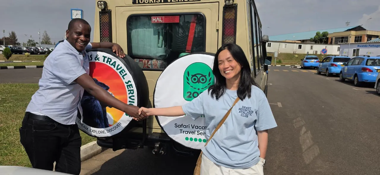 7 Day Uganda Safari: Best Wildlife Safari Tour 2026/2027 33 Safari Vacations and Travel Services Ltd guide welcoming a traveler beside a safari vehicle in Rwanda