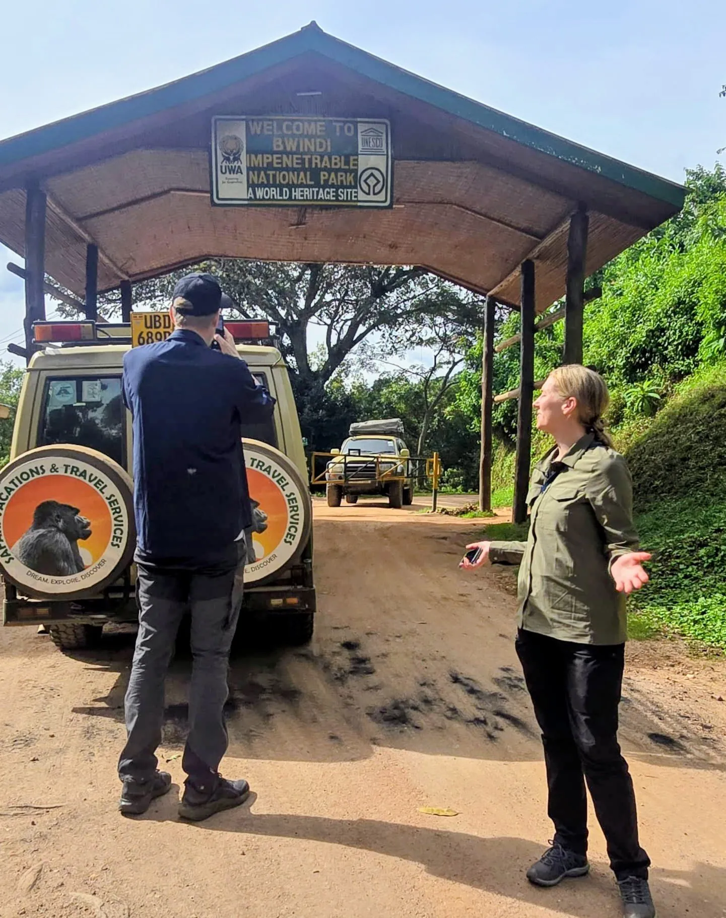 Rwanda vs Uganda Safari: Which Is Best? 2026/2027 7 Travelers with a Safari Vacations and Travel Services Ltd 4x4 vehicle at the entrance to Bwindi Impenetrable National Park during a Rwanda vs Uganda gorilla trekking safari
