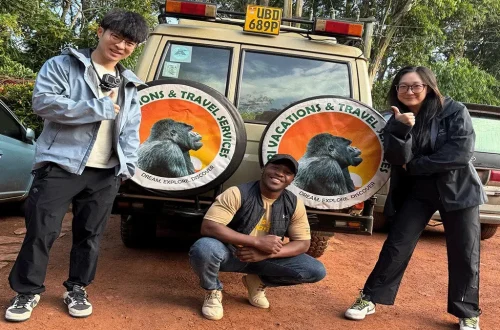Ultimate Uganda Airport Guide: Best Travel Tips (2026/2027) 15 Travelers with a Safari Vacations and Travel Services Ltd representative beside a branded safari vehicle during an Entebbe Airport transfer in Uganda
