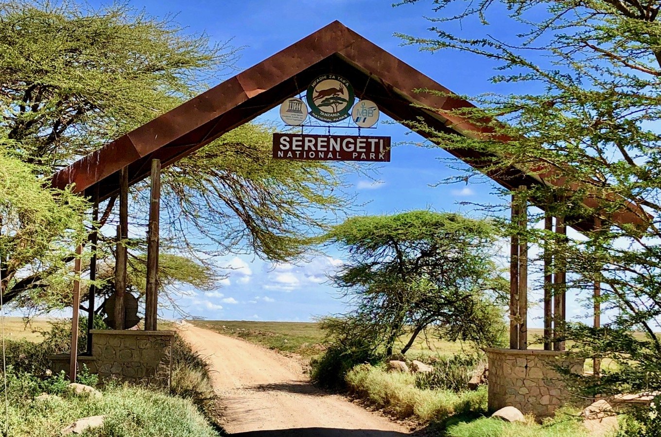 East Africa Safari Guide: Cost, Best Time & Routes 2026/2027 25 Entrance gate to Serengeti National Park in Tanzania surrounded by acacia trees and open savannah