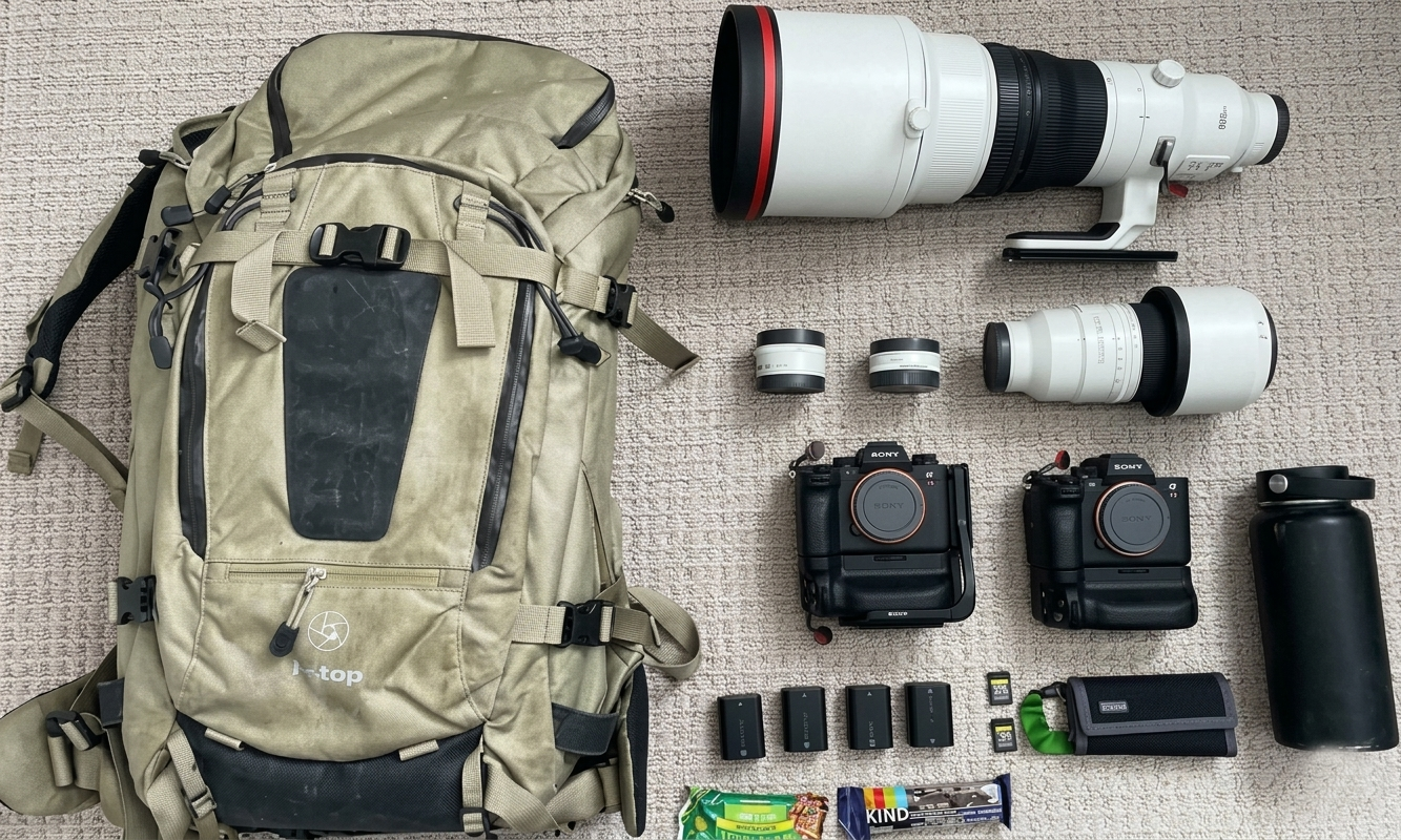 Gorilla trekking for photographers 15 F-stop camera backpack laid out next to Sony bodies, lenses, and batteries.
