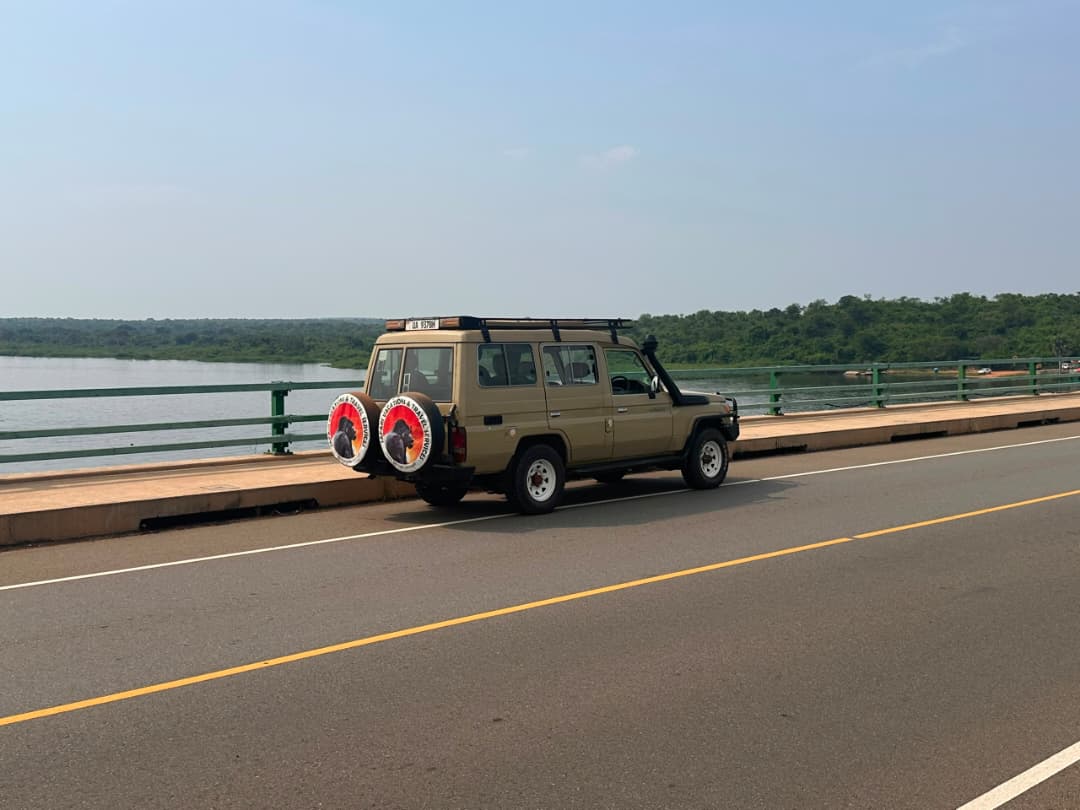 Queen Elizabeth National Park Guide 41 A tan 4x4 safari car parked on a paved bridge over water