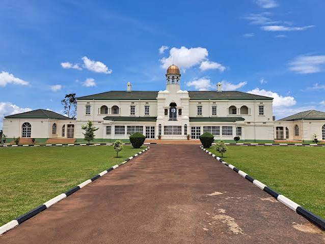 Uganda Culture Guide 25 A large white two-story palace with a central golden dome under a blue sky