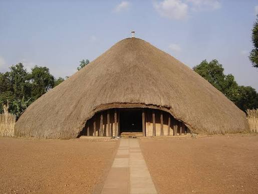 Uganda Culture Guide 27 Large circular thatched hut of the Kasubi Tombs under a clear sky.