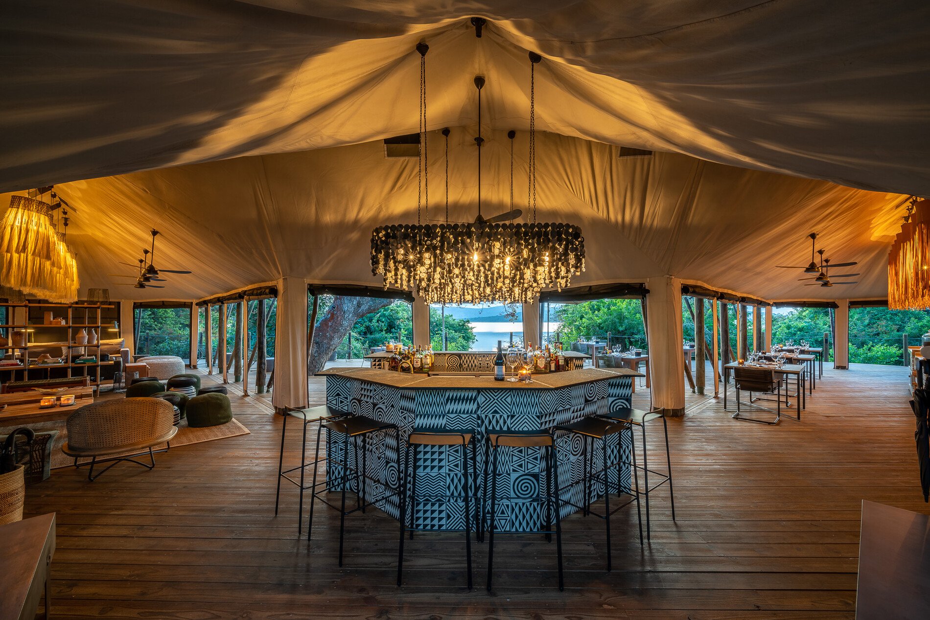 Indoor view of a luxury tented safari lounge with a patterned central bar.