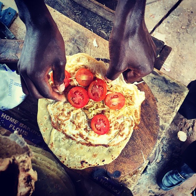 Uganda Food Guide 15 Ugandan Rolex street food being prepared with chapati eggs cabbage and tomatoes