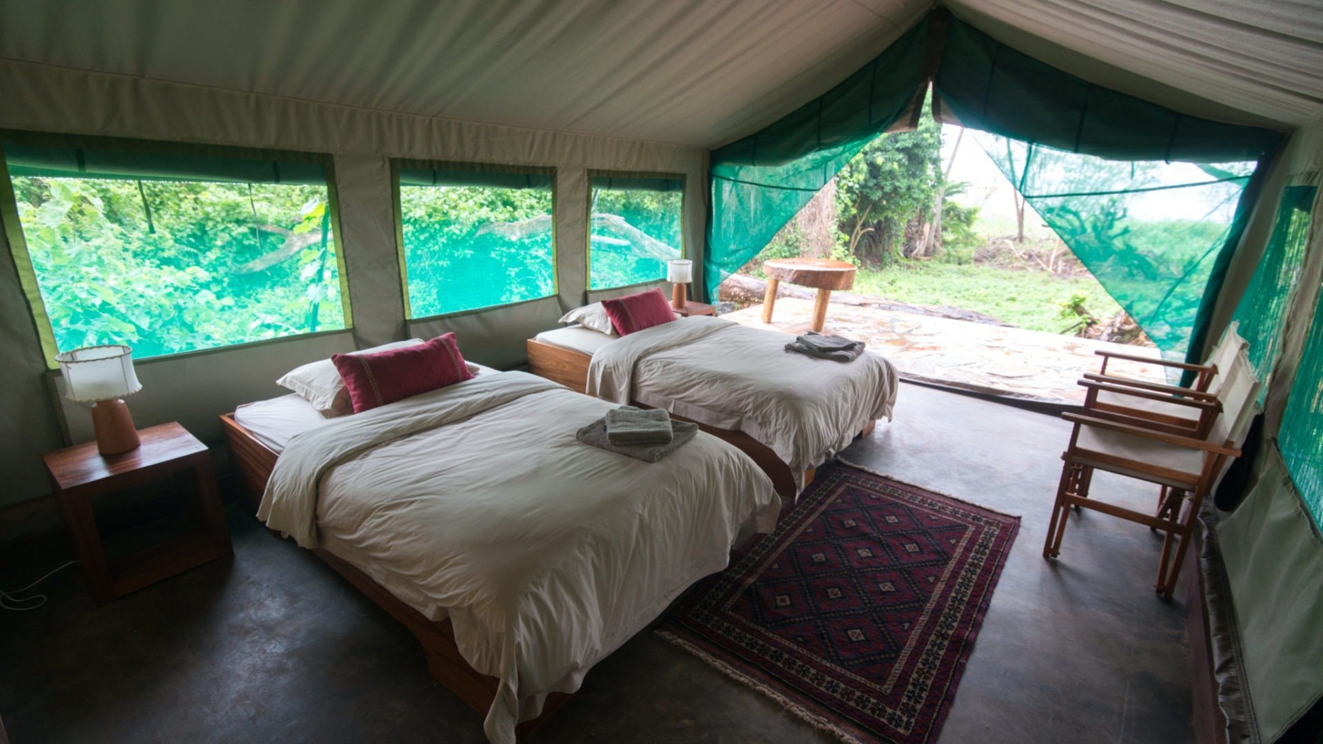 Eco-lodge tent interior with two twin beds and a private deck.