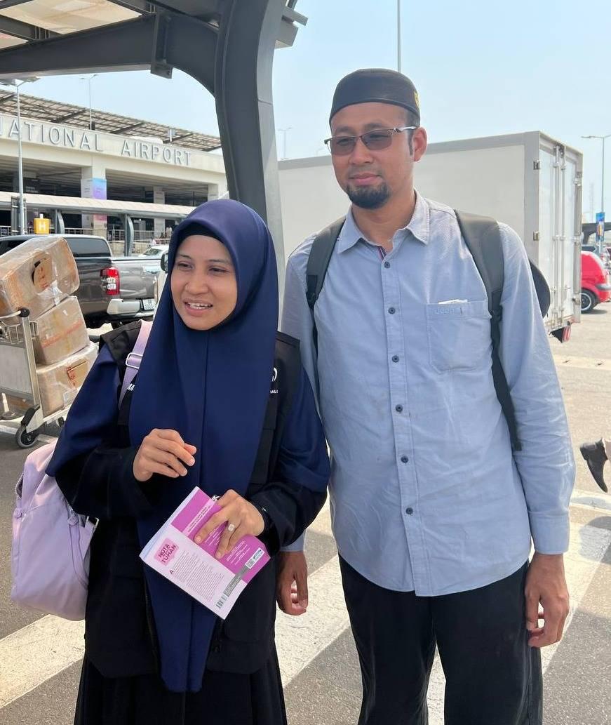Malaysian Muslim travelers at an international airport preparing for flights from Malaysia to Uganda