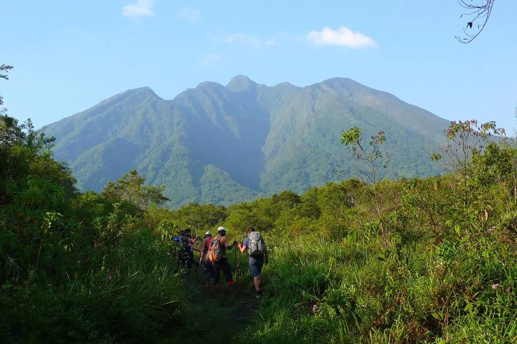 Gorilla Trekking in Uganda & Rwanda | 2026–2027 Guide 3 Hikers combining Gorilla Trekking with Mount Sabyinyo in Mgahinga Gorilla National Park