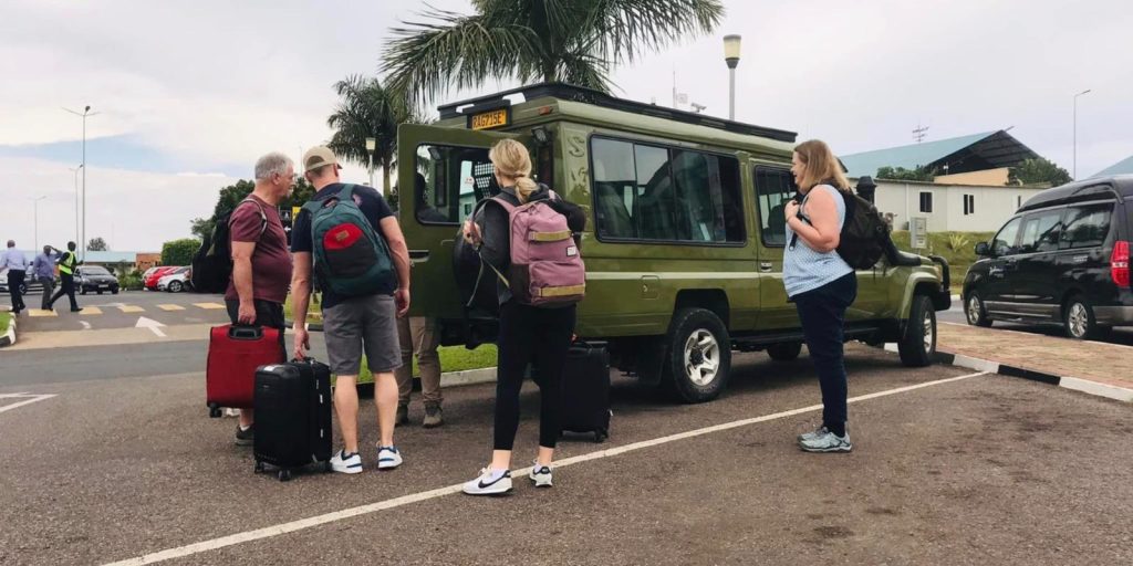 Safari travelers collecting luggage after arriving in Uganda